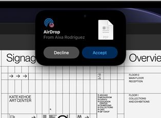 Display shows Dynamic Island with an AirDrop request in a small window over an open Adobe Acrobat file