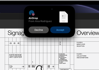 Display shows Dynamic Island with an AirDrop request in a small window over an open Adobe Acrobat file